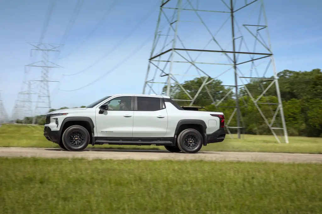 A Chevrolet Silverado EV WT in front of large power lines