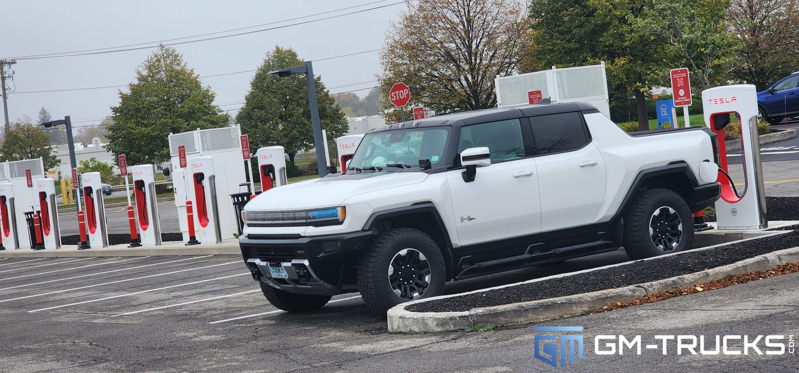 A GMC HUMMER EV At a Tesla Supercharger Station