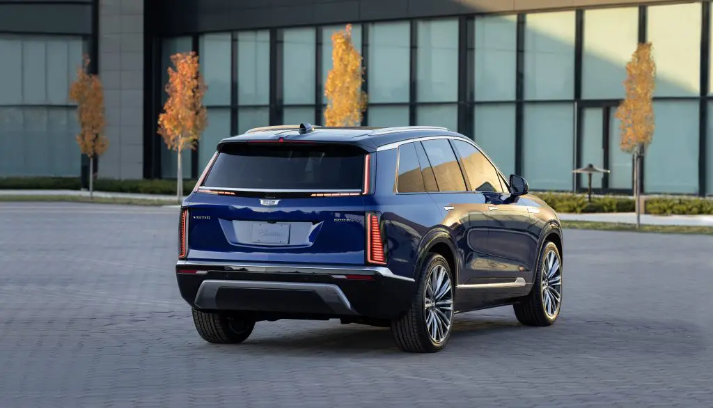 Rear view of the 2026 Cadillac Vistiq EV in blue, showcasing its vertical taillights and sleek design.