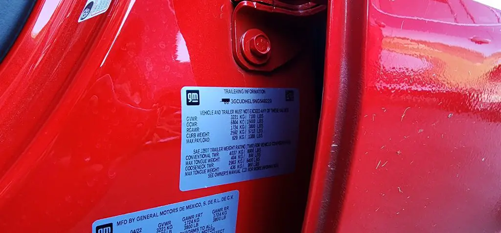 Trailering information sticker on the driver’s door jamb of a Chevrolet Silverado, displaying weight and towing capacity details.