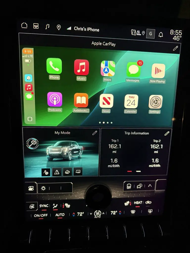 GMC Sierra EV infotainment screen displaying the Apple CarPlay interface with vehicle data and trip information panels visible below.